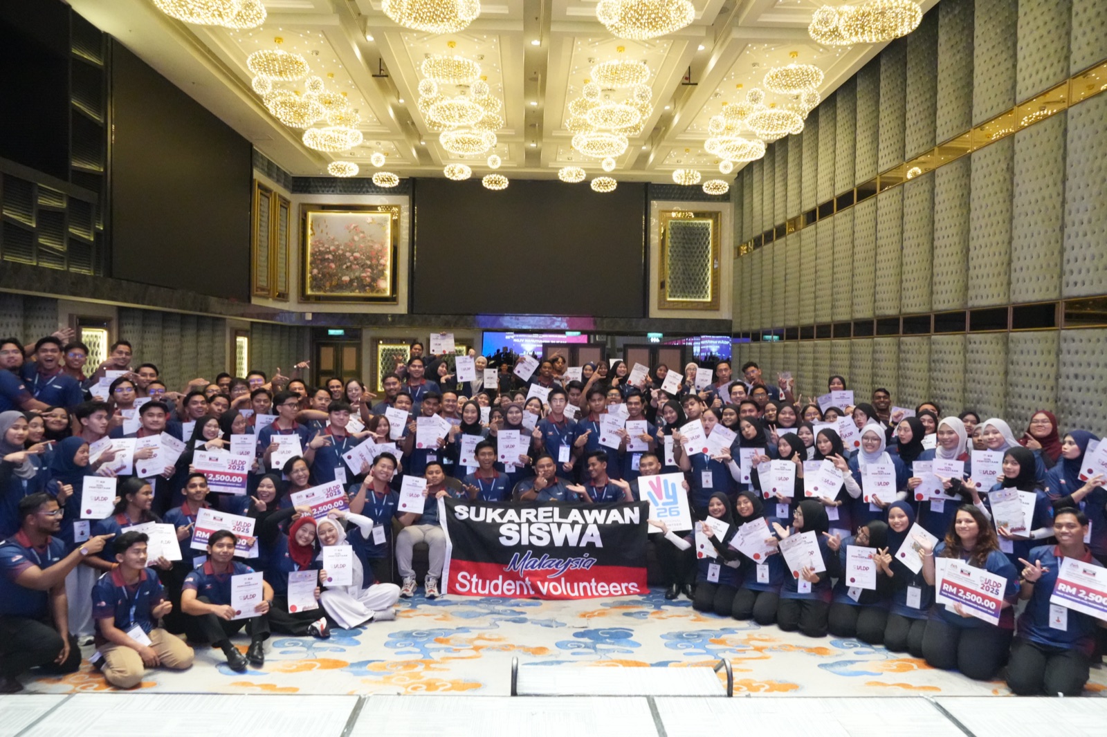 Large cohort of YSS student volunteers holding certificates at a graduation ceremony
